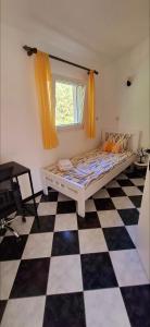 ein Schlafzimmer mit einem Bett und einem Schachbrettboden in der Unterkunft Apartment Vujosevic D&D in Kotor + 25 Fotos