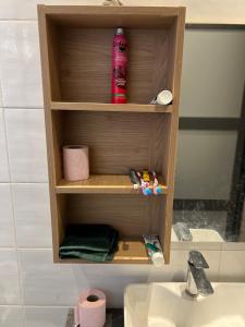 une étagère en bois dans une salle de bain à côté d'un lavabo dans l'établissement Appartement meublé avec cuisine équipée, au bord la mer, à Guediawaye 17 autres photos