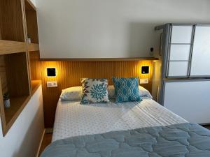 Un dormitorio con una cama grande con almohadas azules. en Apartamento Beach&Relax Chipiona, en Chipiona