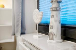 a white lighthouse sitting on top of a table at Haus Lith Deichblick in Nordstrand +17 photos