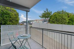 a table and chair on a balcony with a fence at Edge of Heaven in Wanaka