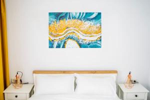 a bedroom with a bed and a painting on the wall at TeCa apartament in Rădăuţi