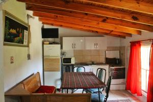 una cocina con mesa y una cocina con refrigerador en Complejo Salamanca - Cabaña La Catalana, en Trapiche