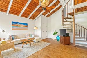 a living room with a staircase and a couch at Beautiful 2 Br 2.5 Ba Condo Golf Course View, Pool, Hot Tub (209AB) in Princeville