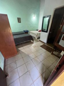 a room with two beds and a tiled floor at Posada el Yacaré in Colonia Carlos Pellegrini