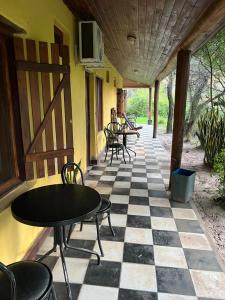 a patio with tables and chairs on a checkered floor at Posada el Yacaré in Colonia Carlos Pellegrini +1 photo