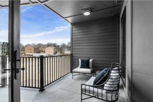 un balcón con sofá y 2 sillas. en Electric - Odyssey -Top Floor West End 2 Bedroom - Minutes to Broadway, en Nashville