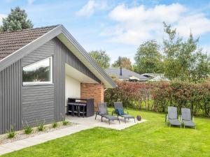 un patio avec des chaises et un barbecue dans une cour dans l'établissement Luxury Retreat with Pool - By Traum Ferienwohnungen, à Sønderby