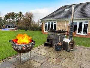 a fire pit and a grill in a yard at The Firs in Boston