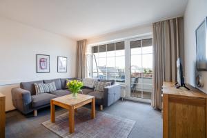 een woonkamer met een bank en een tafel bij DKK7 Ferienwohnung Abendsonne F in Niendorf