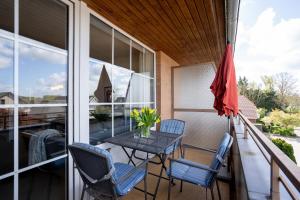 een terras met een tafel en stoelen op een balkon bij DKK7 Ferienwohnung Abendsonne F in Niendorf