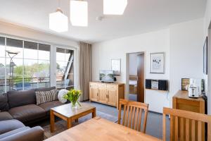 een woonkamer met een bank en een tafel bij DKK7 Ferienwohnung Abendsonne F in Niendorf