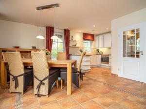 Una cocina y un comedor con mesa y sillas de madera. en Villa Kormoran, en Dierhagen