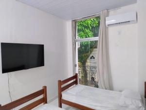 a room with a tv and a window at ABA Hotel in Belém
