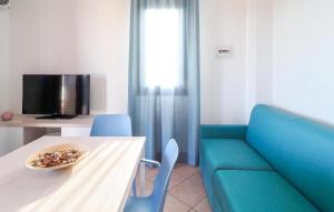 ein Wohnzimmer mit einem Tisch und einem blauen Sofa in der Unterkunft Nice Home In Marina Di Modica in Marina di Modica