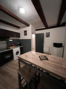 a kitchen with a wooden table in a room at Spacieux 61 metres carré tout confort in Grandvillars +13 photos