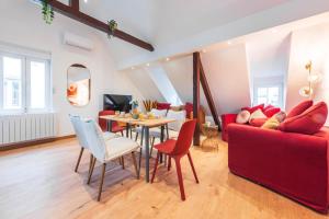 a living room with a red couch and a table at Le Robin des Toits - Moderne in Schiltigheim