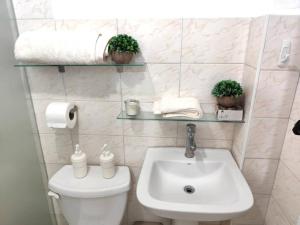 a bathroom with a white toilet and a sink at Your Tropical HouseRD in La Francia +28 photos