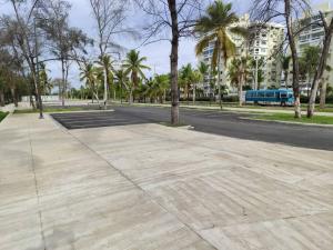 an empty street with palm trees and a bus at Your Tropical HouseRD in La Francia
