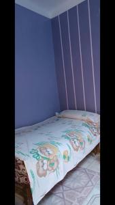 a small bed in a room with a bedspread with animals on it at محافظه اسوان جزيره اسوان النجع البحرى in Aswan