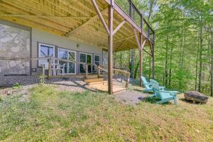 a home with a covered porch and two blue chairs at Sweeping Smoky Mountain Views Bella Vista Cabin in Whittier