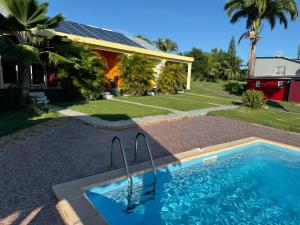 ein Swimmingpool vor einem Haus in der Unterkunft Gîte Allée des Cocotiers in Saint-François