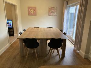 a wooden table in a room with chairs around it at Large 4 bed detached house with parking in Newark-on-Trent