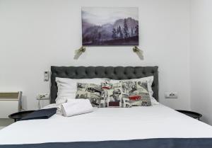 een slaapkamer met een wit bed met een stapel kussens bij Natalie's Inn in Belgrado