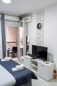 een slaapkamer met een bed en een flatscreen-tv bij Natalie's Inn in Belgrado