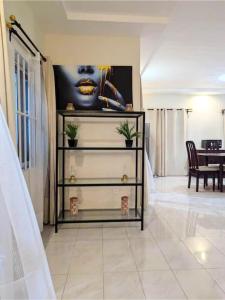 a living room with a dresser with a picture on the wall at Atlantika, Clim, Fidjrossè Plage in Cotonou