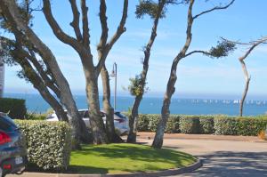a parking lot with trees and the ocean in the background at Appartements front de Mer SABLES D'OLONNE in Les Sables-dʼOlonne +105 photos