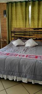 a bed with two pillows on top of it at ALASA Hospedaje in Los Ángeles