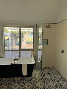 a bathroom with a tub and a glass shower at Tarra by the Tides in Tarraville