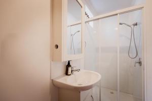 une salle de bain blanche avec lavabo et douche dans l'établissement Fenton Cottage, à Hobart 24 autres photos