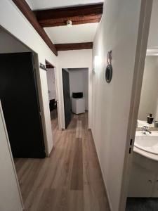 a hallway with a sink and a bathroom at Spacieux 61 metres carré tout confort in Grandvillars