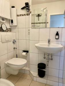 Un baño blanco con inodoro y lavabo. en Prinzenhof "Lieblingsplatz" App 27 inkl WLAN, en Grömitz