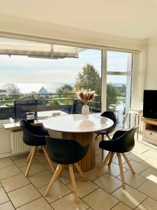 Un comedor con mesa y sillas y una gran ventana. en Prinzenhof "Lieblingsplatz" App 27 inkl WLAN, en Grömitz
