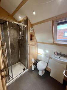 a bathroom with a shower and a toilet and a sink at Sunnybank by Wigwam Holidays in Reston