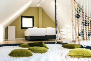 a bedroom with green pillows and a bed in the attic at Wyjątkowy domek w kompleksie Patyki Las Możliwości in Zelów