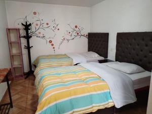 una camera da letto con un letto con un murale di un albero sul muro di Redys House a Cuzco
