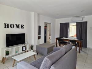a man in a living room with a couch and a table at Apart Origenes 1 in Villa Regina