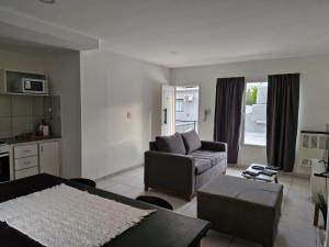 a living room with a couch and a table at Apart Origenes 1 in Villa Regina