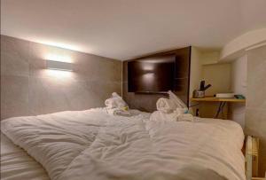 Una cama blanca grande con toallitas. en Cosy room inside Batignolles - L60, en París