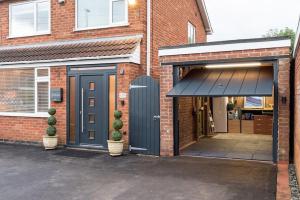 a garage with a blue door on a brick building at Triumph House in Hinckley