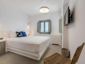 una camera bianca con un grande letto e una televisione di Stunning villa with modern decor a Agios Sostis Altre 22 foto