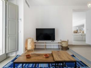 un soggiorno con un tavolo e una TV di Stunning villa with modern decor a Agios Sostis