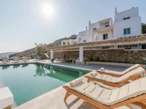 una villa con piscina e 2 sedie a sdraio di Stunning villa with modern decor a Agios Sostis