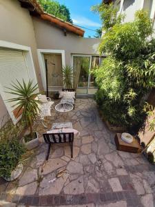 a patio with a table and chairs in front of a house at Casa alquiler temporario miramar in Miramar