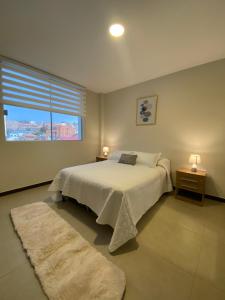 スクレにあるDepartamento en barrio Petroleroのベッドと大きな窓のある寝室 +30枚の写真