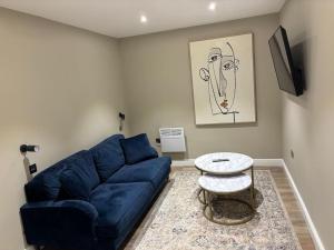 a living room with a blue couch and a table at Central Leeds - 2 Bed Ensuite in Leeds